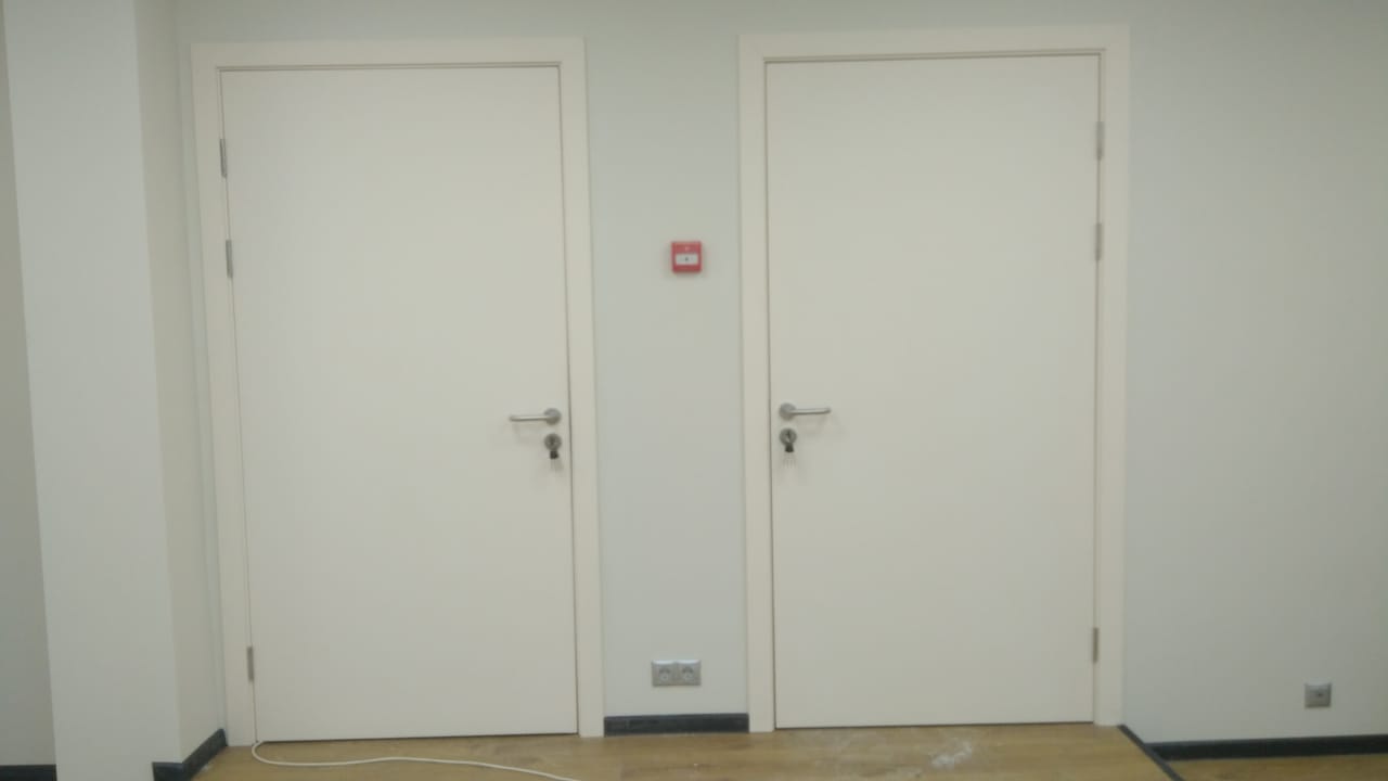 Белые распашные двери в кладовое помещение торгового центра