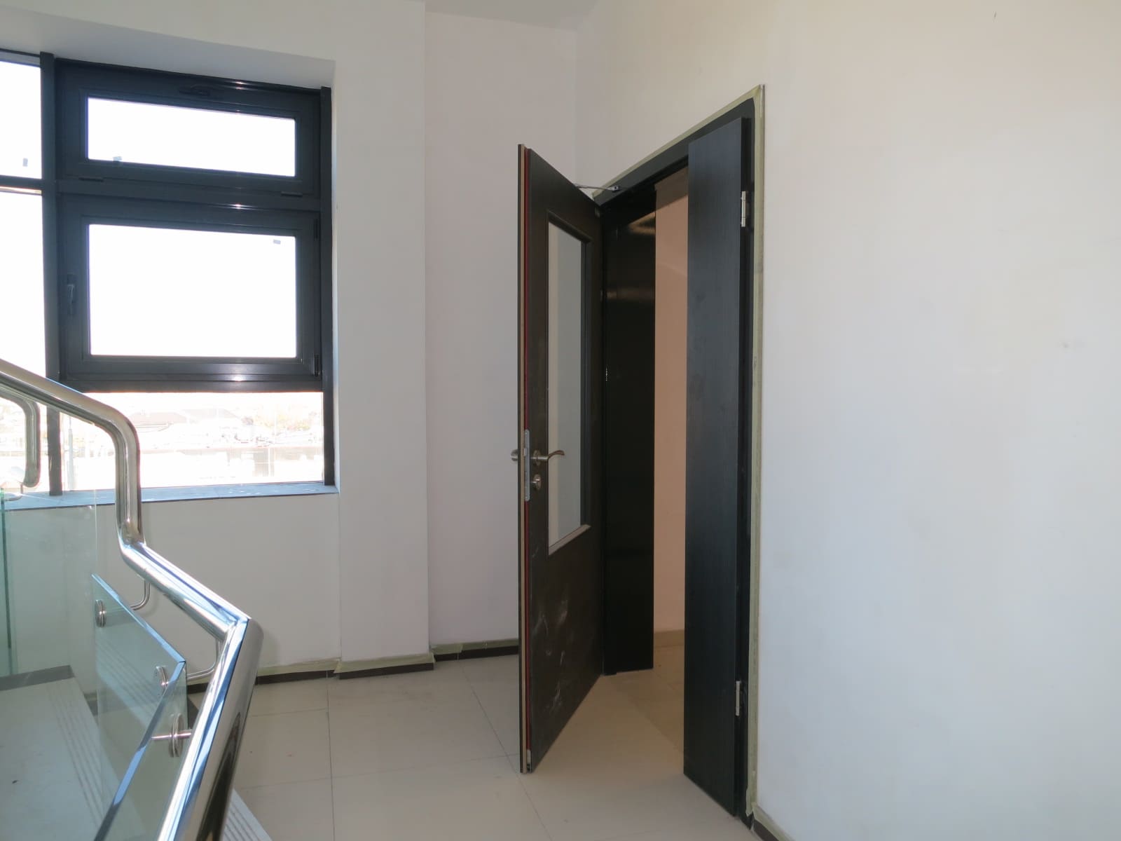 Двустворчатая дверь со стеклом, установленная в подъезде общежития перед лестницей